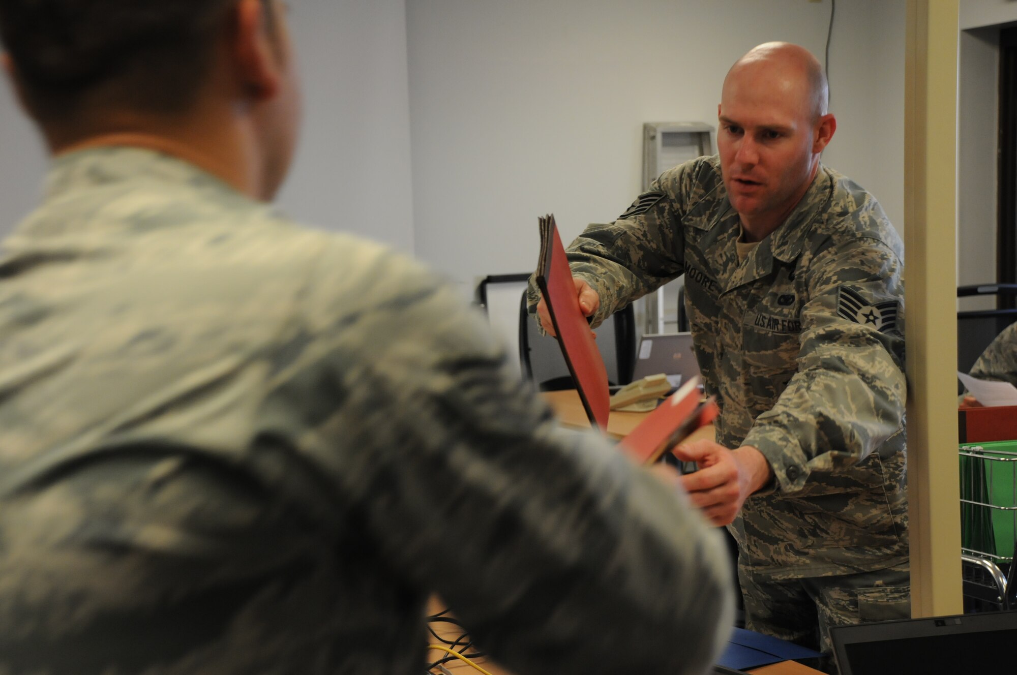 Staff Sgt. Michael Moore assists members of the 914th Security Forces Squadron with pre-deployment instructions at Niagara Falls Air Reserve Station, N.Y. on April 12, 2015. Moore handles many of the tasks associated with pre and post deployment for his unit. (U.S. Air Force photo by Staff Sgt. Matthew Burke)