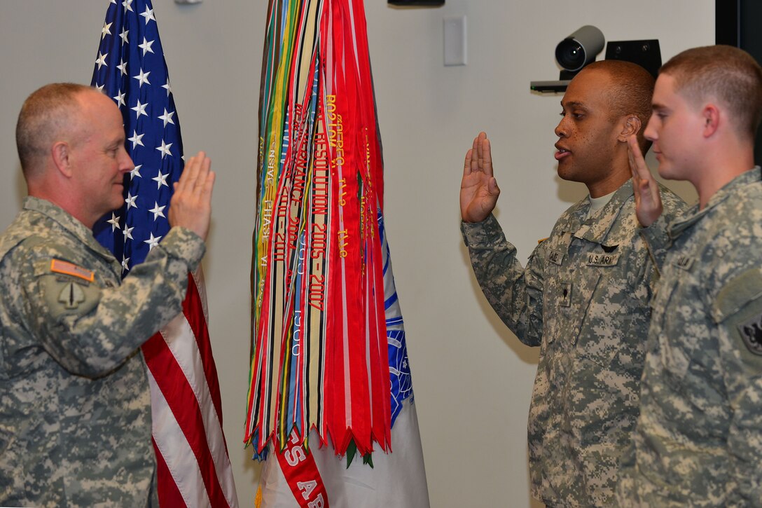 U.S. Army Lt. Gen. Kevin W. Mangum, U.S. Army Training and Doctrine Command deputy commander, re-enlists two  U.S. Army Reserve Soldiers at TRADOC on Fort Eustis, Va., April 23, 2015.  Mangum enlisted the two soldiers as part of the U.S. Army Reserve’s 107th birthday celebration. (U.S. Air Force photo by Staff Sgt. Natasha Stannard/Released) 