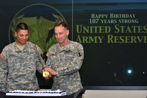 U.S. Army Maj. Gen. Jeffrey E. Phillips, U.S. Army Reserve deputy commander, right, cuts the U.S. Army Reserve birthday cake with Private 1st Class Jose Gonzales, 1st-1222 Bravo Company Aviation Regiment avionic mechanic, at U.S. Army Training and Doctrine Command on Fort Eustis, Va., April 23, 2015. Gonzales was selected as the youngest Army Reserve Soldier in the local area to cut the cake with the General. (U.S. Air Force photo by Staff Sgt. Natasha Stannard/Released) 