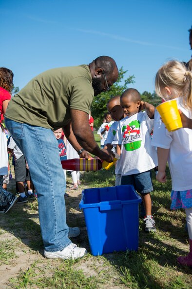 Elvis Lane, 23d Civil Engineer Squadron environmental specialist, teaches children how to recycle during an Arbor Day tree planting ceremony April 24, 2015, at Moody Air Force Base, Ga. Lane visited multiple Valdosta schools and the Youth Center this week to speak to children about the importance of recycling for Earth Day. (U.S. Air Force photo by Airman 1st Class Dillian Bamman/Released)