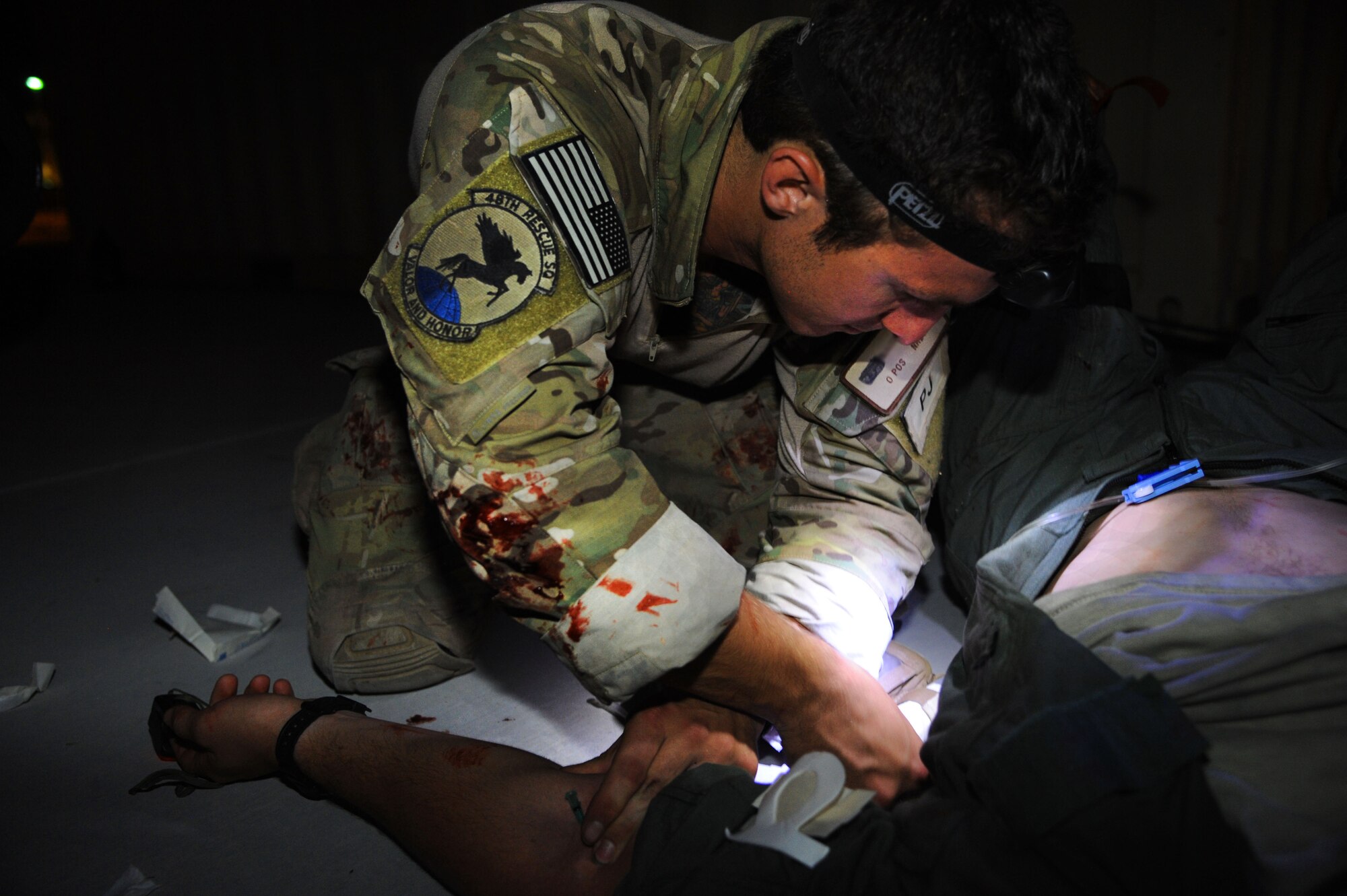 A U.S. Air Force Senior Airman, 48th Rescue Squadron, prepares to initiate an IV fluid resuscitation on a simulated patient during a pre-deployment training exercise at Davis-Monthan Air Force Base, Ariz., April 14, 2015.  Several Airmen from D-M participated in the exercise as simulated victims to create a realistic training environment. Due to security concerns, the Airman’s name is withheld. (U.S. Air Force photo by Senior Airman Betty R. Chevalier)