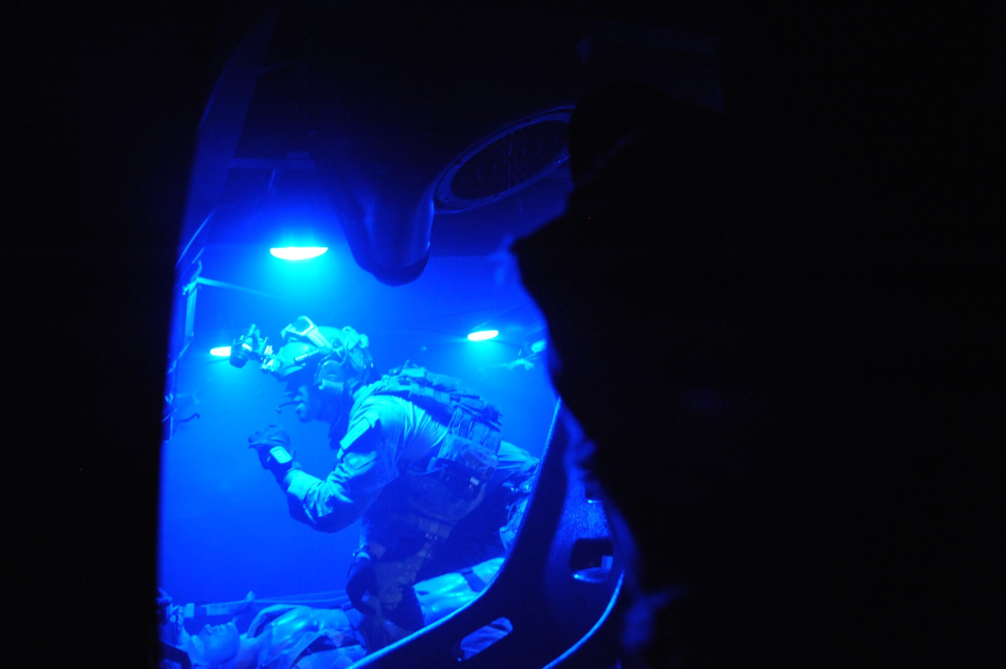 A U.S. Air Force Pararescueman, 48th Rescue Squadron, communicates with his team on the condition of a simulated patient inside a training helicopter during a pre-deployment training exercise at Davis-Monthan Air Force Base, Ariz., April 14, 2015. The exercise provided training in a controlled environment allowing Airmen to safely work through the elements of stress and complexity that are realistic with real world situations. (U.S. Air Force photo by Senior Airman Betty R. Chevalier)