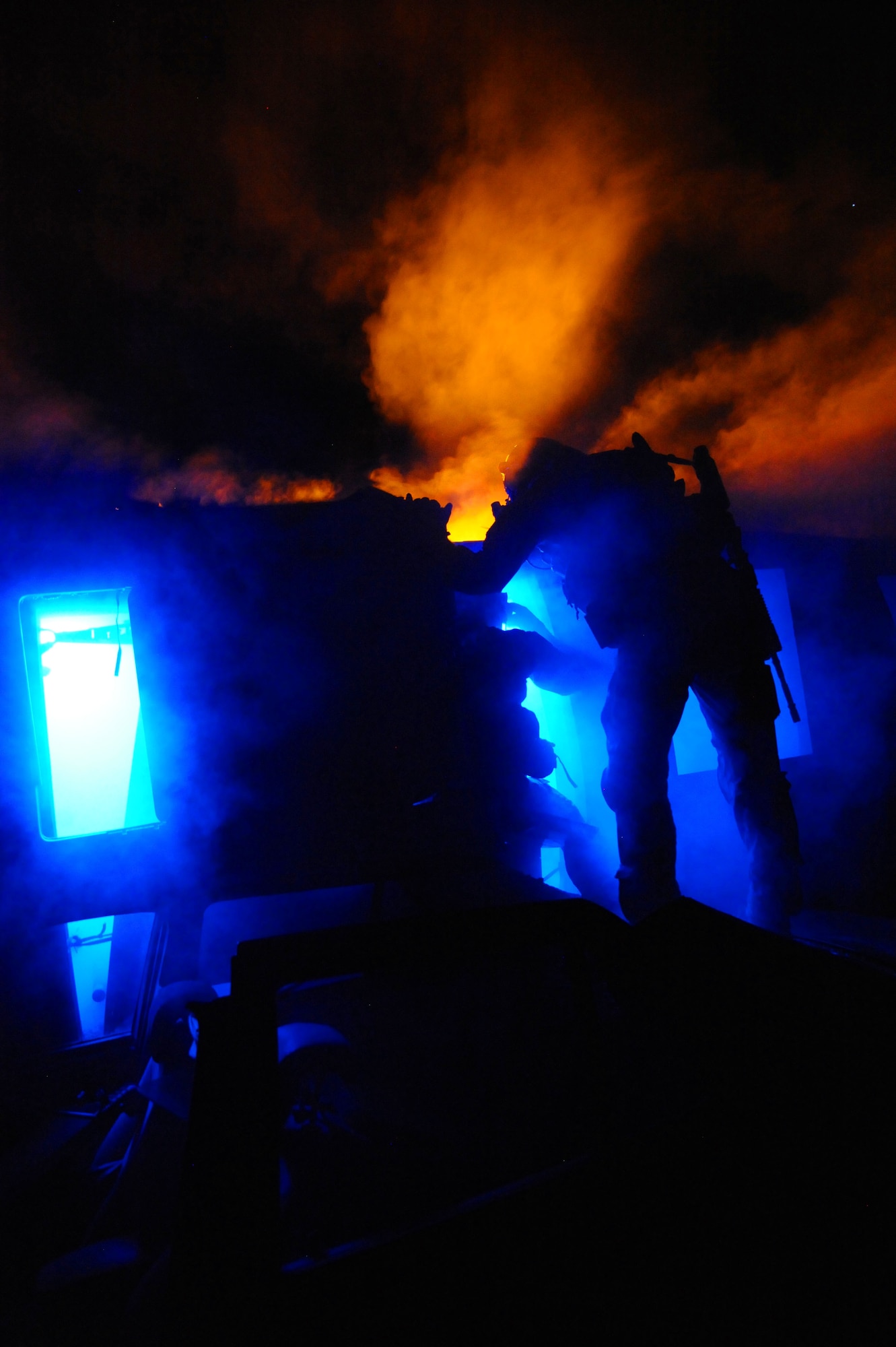 U.S. Air Force Pararescuemen, 48th Rescue Squadron, enter a simulated downed helicopter during a pre-deployment training exercise at Davis-Monthan Air Force Base, Ariz., April 14, 2015. The Airmen were evaluated on how their response to mass casualty situations, including their ability to call in air support for casualty evacuation. (U.S. Air Force photo by Senior Airman Betty R. Chevalier)