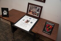 Iggy’s, 436th Security Force Squadron military working dog, discharge certificate and photos rest on a table April 22, 2015, at Dover Air Force Base, Del. Iggy served five years and deployed three times throughout her career. (U.S. Air Force photo/Senior Airman Jared Duhon) 