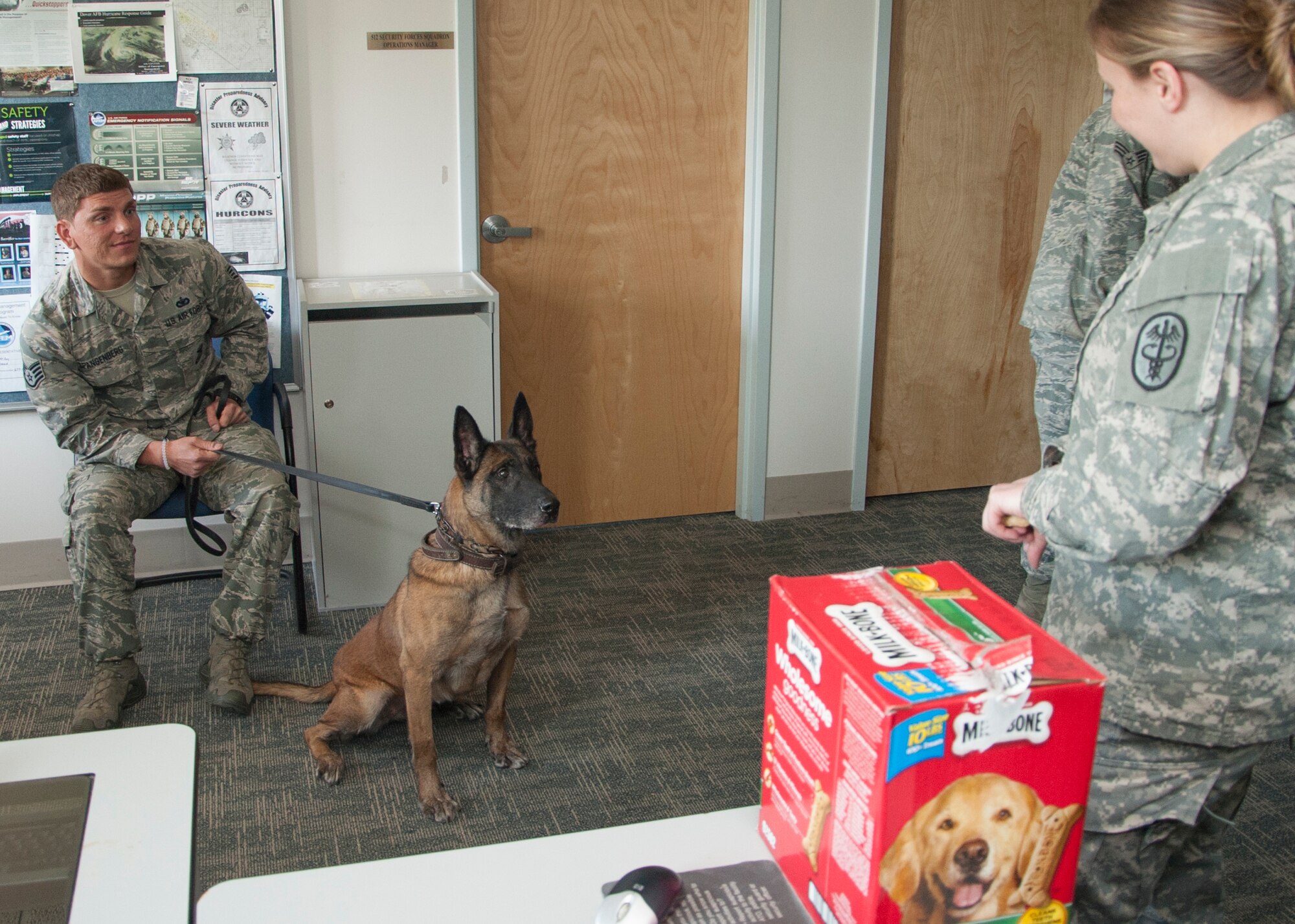 Iggy, 436th Security Force Squadron military working dog, waits for a treat from U.S. Army Capt. Amanda Jeffries, Veterinary Treatment Facility officer in charge and veterinarian, during her retirement ceremony April 22, 2015, at Dover Air Force Base, Del. Iggy has conducted searches of more than 3,000 commercial vehicles, safeguarding Dover AFB. (U.S. Air Force photo/Senior Airman Jared Duhon)  