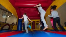The children of deployed Team Dover Airmen jump in a bouncy castle during the Deployed Families Dinner April 23, 2015, at the Youth Center on Dover Air Force Base, Del. Two bouncy castles were set up for the children to jump in. (U.S. Air Force photo/Airman 1st Class Zachary Cacicia)