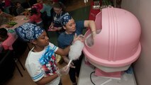 Airman 1st Class Onise Civil, 436th Dental Squadron dental assistant, left, and Capt. Rose Tran, 436th DS dentist, make cotton candy during the Deployed Families Dinner April 23, 2015, at the Youth Center on Dover Air Force Base, Del. The dinner’s theme was super heroes. (U.S. Air Force photo/Airman 1st Class Zachary Cacicia)