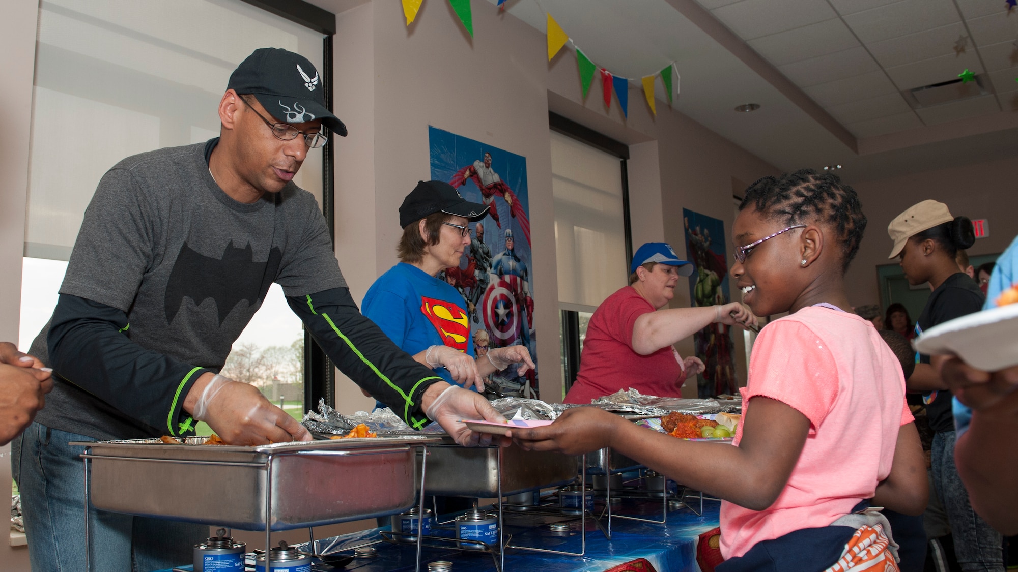 Lt. Col. Eric Baugh, 436th Dental Squadron commander, serves food to Kira Dunnah, daughter of Staff Sgt. Lavontre Chamberlin, 436th Medical Support Squadron pharmacy technician, during the Deployed Families Dinner April 23, 2015, at the Youth Center on Dover Air Force Base, Del. The 436th Medical Group, in conjunction with the chapel hosted this dinner. (U.S. Air Force photo/Airman 1st Class Zachary Cacicia) 