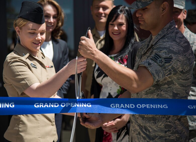 Seaman apprentice Alissa Hipner, left, and Senior Airman Hans Gomez, 89th Communication Squadron electrical power production apprentice, cut the ribbon for the opening of the Community Commons at Joint Base Andrews, Md., April 24, 2015. The Community Commons aims to foster a deeper sense of community on JBA. (U.S. Air Force photo/Airman 1st Class Philip Bryant)