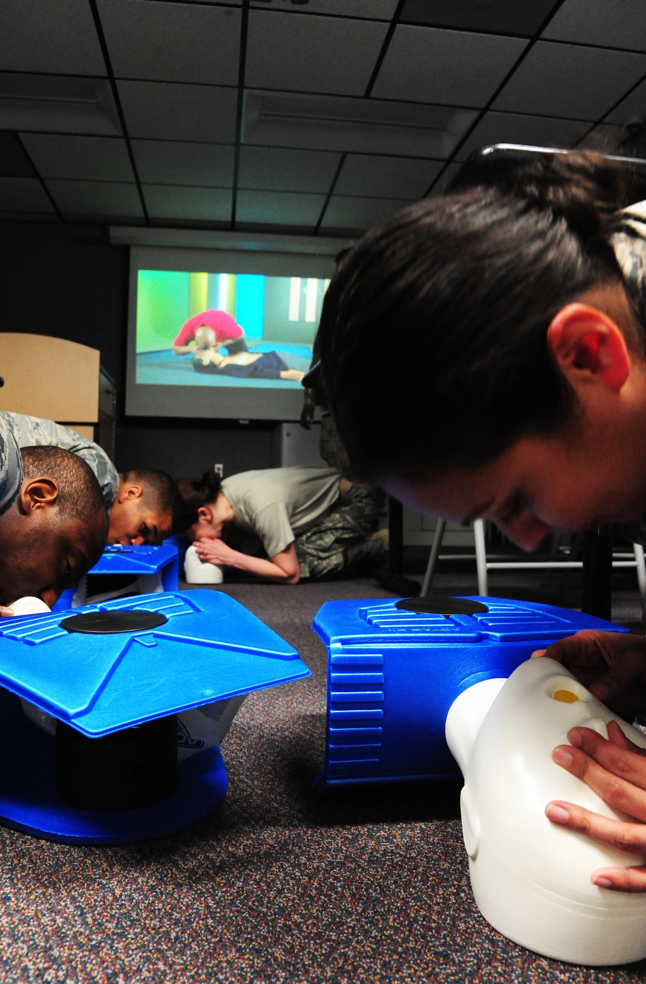Members from the 509th Force Support Squadron fitness facility perform cardiopulmonary resuscitation (CPR) training at Whiteman Air Force Base, Mo., April 8, 2015. Fitness center personnel are required to be certified in CPR training within 30 days of working at the facility. It’s a one day course held in-house and consists of training videos, mannequins and CPR tools used to perform the procedure. (U.S. Air Force photo by Senior Airman Keenan Berry/Released)  