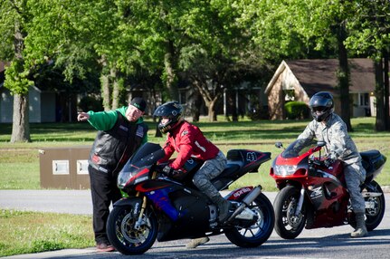Chris Bender, Green Knights Motorcycle Club Chapter 37 member, directs motorcyclists where to park for the Annual Motorcycle Riders Safety Brief , April 24, 2015 at Joint Base Charleston – Air Base, S.C. The Annual Motorcycle Safety Brief is required by AFI 91-207, The Air Force Traffic Safety Program, paragraph 1.3.4.5. for all active duty Air Force motorcycle riders. All other service members, retirees, and dependents are highly encouraged to attend. (U.S. Air Force photo/Staff Sgt. AJ Hyatt)