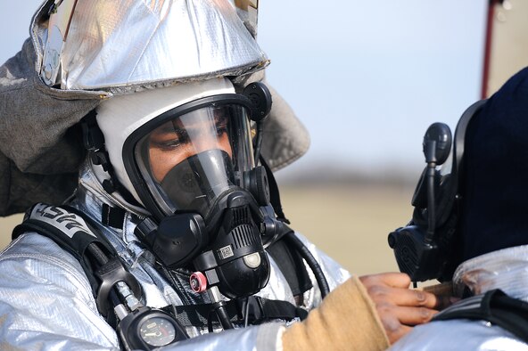 Firefighters of the 509th Civil Engineer Squadron examine each other’s gear during a fire pit training at Whiteman Air Force Base, Mo. April 2, 2015. The exercise uses controlled burns to simulate conditions of a real-world crash site. (U.S. Air Force photo by Airman 1st Class Jovan Banks/Released)

