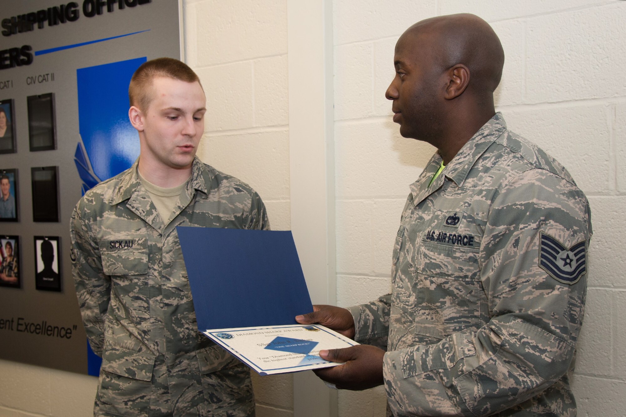 Staff Sgt. John Sickau, Joint Personal Property Shipping Office Northeast shipping distribution technician, is presented the Diamond Sharp Award by Tech. Sgt. David Walls, JPPSO Storage Management NCO in charge, as well as the acting JPPSO first sergeant, during a presentation April 24. The first sergeants selected Sickau as the recipient of the award for performance reflecting the highest standard of professionalism and pride. The Diamond Sharp program, adopted by the First Sergeant Council, aims to recognize the base’s sharpest personnel in the grades of airman basic through technical sergeant. (U.S. Air Force photo by Mark Herlihy)
