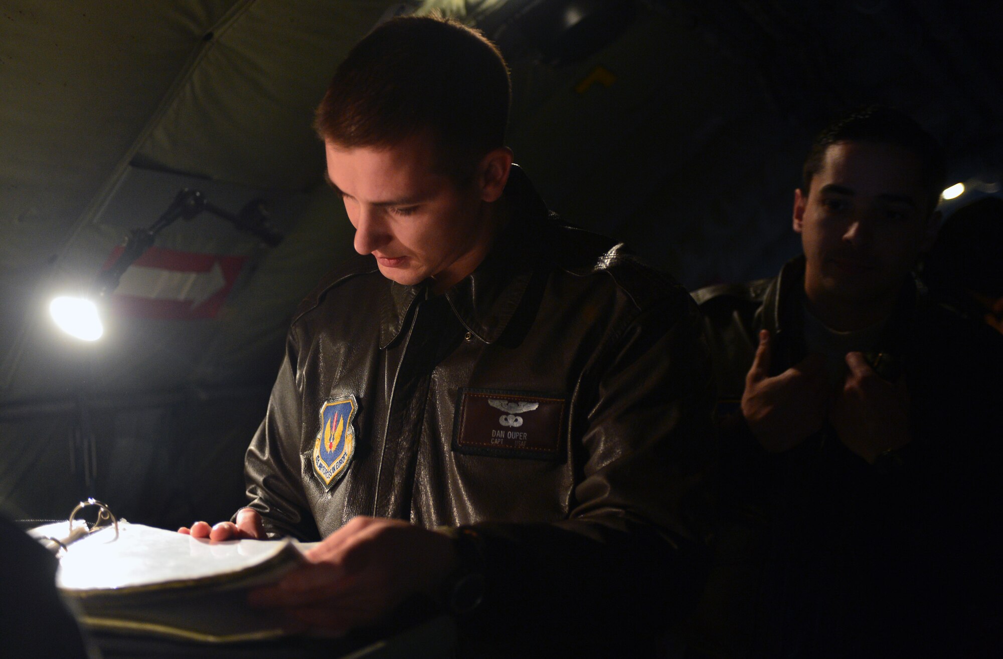 U.S. Air Force Capt. Daniel Ouper, an 871st Air Expeditionary Squadron KC-135 Stratotanker pilot, reads over a pre-flight checklist as U.S. Air Force Capt. Luke Reardon, also a KC-135 pilot with the 871st AES, looks on during Icelandic Air Surveillance and Policing at Keflavik International Airport, Iceland, April 21, 2015. The KC-135 provides air refueling capability to U.S. Air Force fighter assets, increasing their range and increasing mission capability. IAS is a recurring NATO mission designed to maintain the security of Icelandic airspace by providing a fighter aircraft presence in the region. (U.S. Air Force photo by 2nd Lt Meredith Mulvihill/Released)
