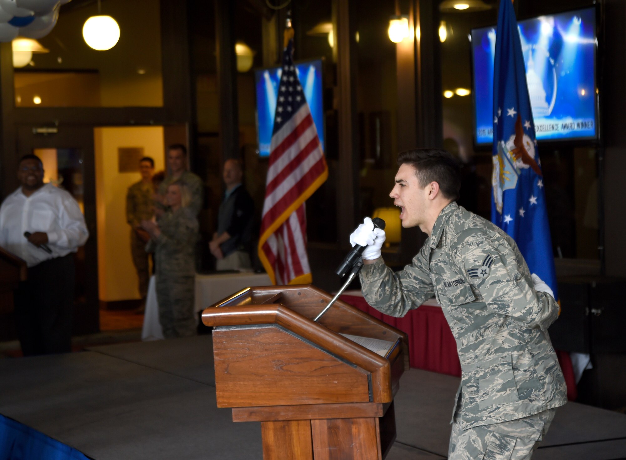 Senior Airman Christian Barnes, Joint Base Andrews Honor Guard member, yells into a microphone to excite the crowd before a celebration at The Courses at Andrews here, April 22, 2015. As the Air Force's top installation, JBA will compete for the Department of Defense’s 2015 Commander in Chief's Installation Excellence Award. (U.S. Air Force photo/Airman 1st Class Ryan J. Sonnier)