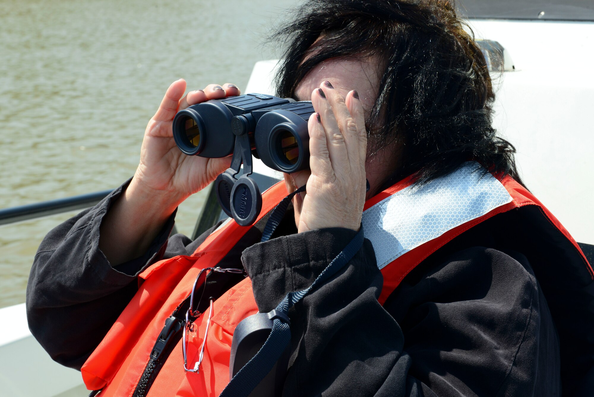 Elizabeth Jarvin, 733rd Civil Engineer Division secretary, looks through binoculars during a wildlife boat tour as part of Earth Week at Fort Eustis, Va., April 21, 2015. The 733rd CED conducted multiple boat tours that took place along the James River and Skiffe’s Creek to educate Service members on wildlife and the community’s ecosystem. (U.S. Air Force photo by Senior Airman Kimberly Nagle/Released)