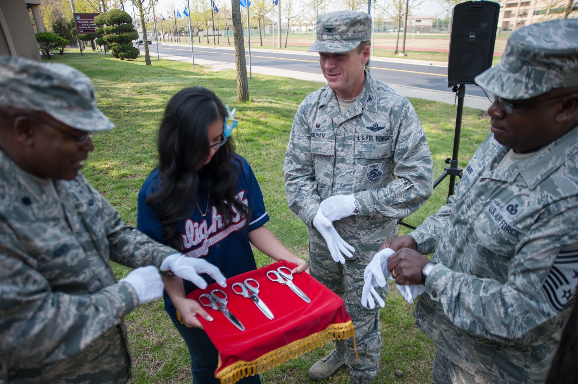 Col. Ken “Wolf” Ekman, 8th Fighter Wing commander, Chief Master Sgt. Lee “Wolf Chief” Barr, 8th FW command chief, and Lt. Col. Dwayne “Shepherd” Jones, 8th FW chaplain, receive gloves and scissors from a proffer for the official ribbon cutting of the Wolf Pack Garden at Kunsan Air Base, Republic of Korea, April 22, 2015. The garden project started March 14 as part of a community initiative to promote healthy living for Wolf Pack Airmen. (U.S. Air Force photo by Tech. Sgt. George Maddon/Released)