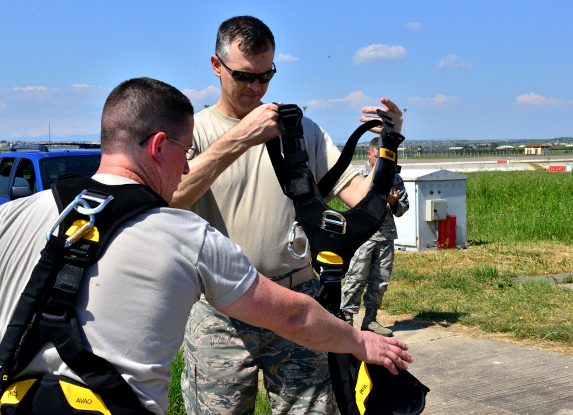 Airman 1st Class Matthew Coyle, 39th Operations Support Squadron air field systems technician, instructs Col. Craig Wills, 39th Air Base Wing commander, on the proper way to fasten a safety harness April 16, 2015, at Incirlik Air Base, Turkey.  Wills visited the Airmen of the 39th OSS as part of his weekly commander’s Out Connecting with Airman Program. (U.S. Air Force photo by Senior Airman Michael Battles/Released) )
