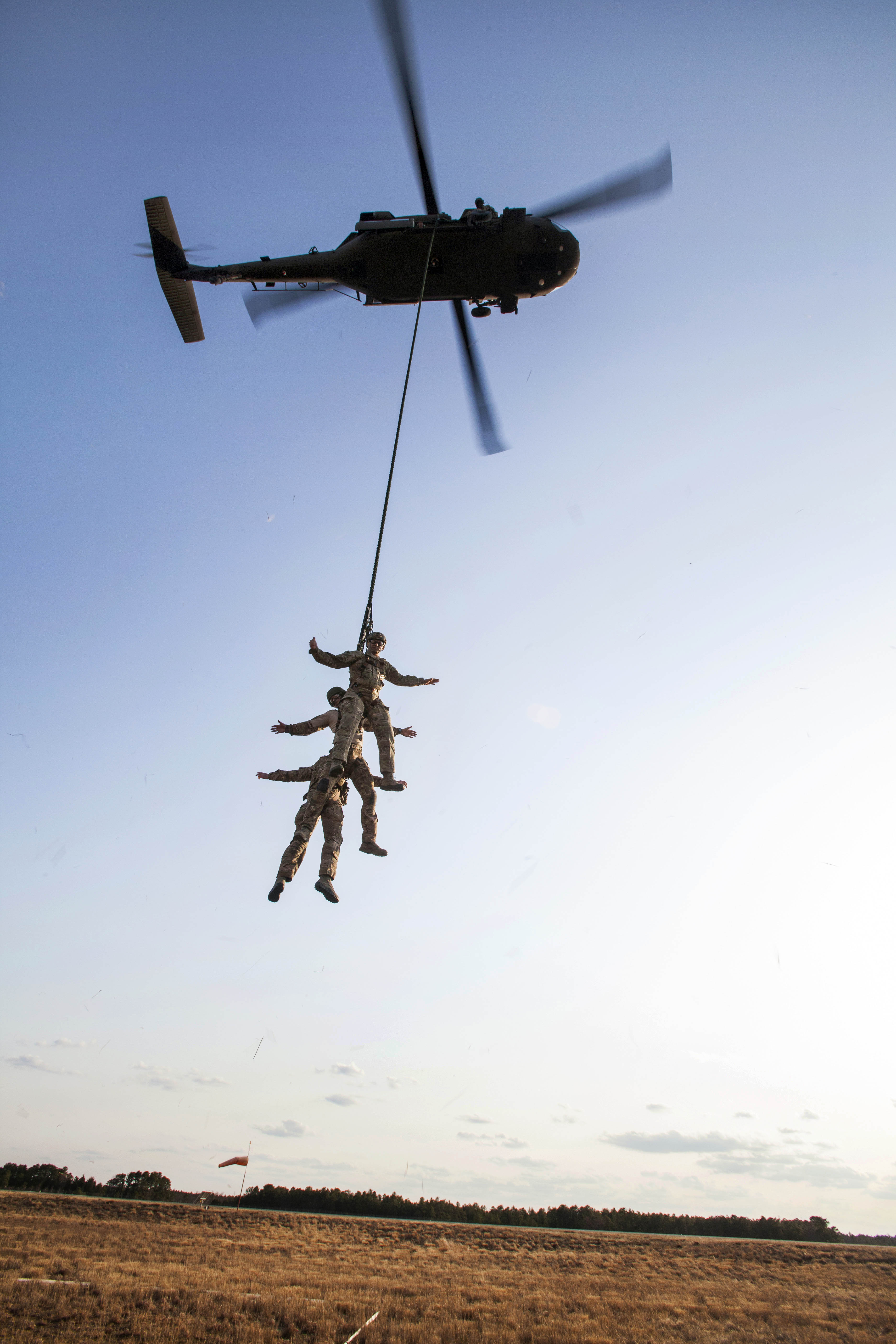 Airmen Are Lifted Up By A Uh 60 Black Hawk Helicopter To A Fast Rope Insertion And Extraction 