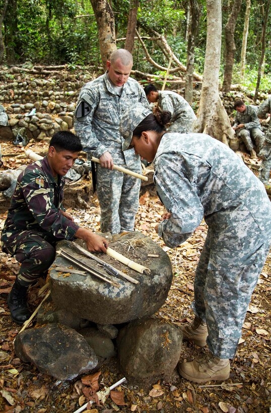 Filipino soldiers show U.S. soldiers how to start a fire using sticks in Fort Magsaysay, Philippines, April 17, 2015. 