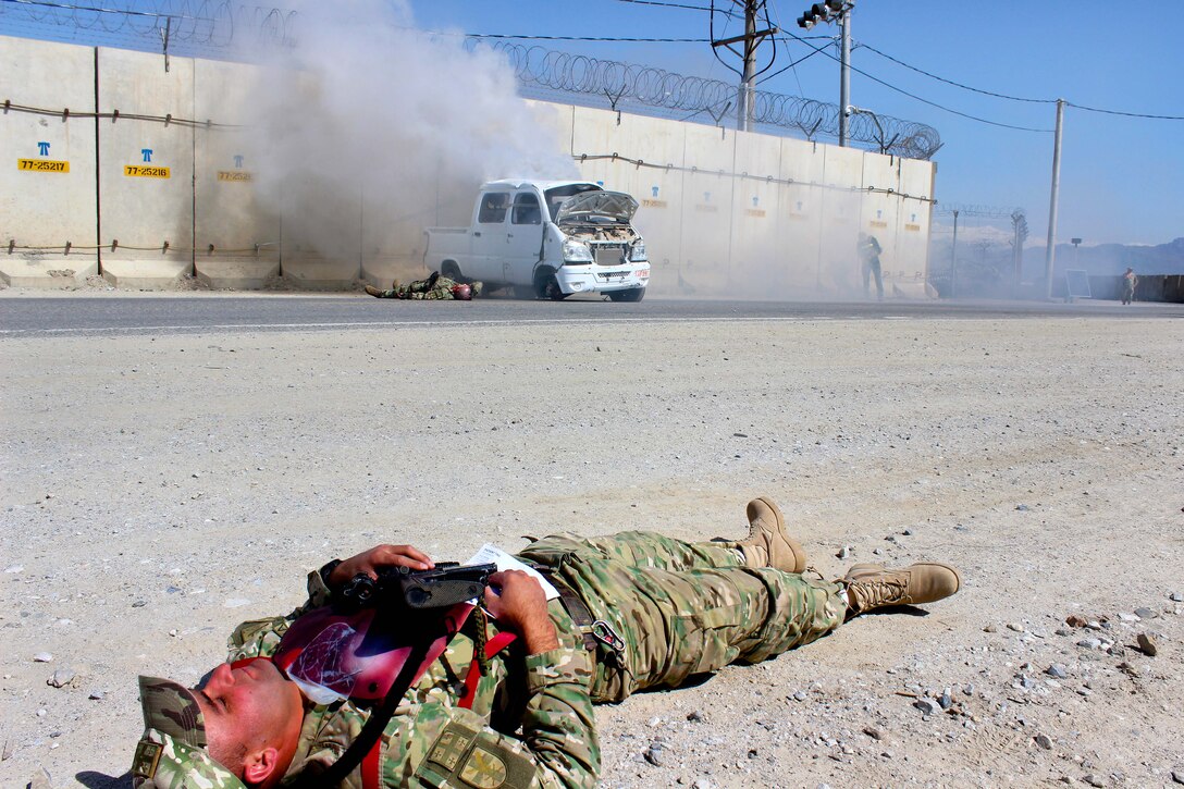 A Georgian soldier roll plays as a mock casualty awaiting medical aid after a improvised explosive device exploded during a base defense emergency response exercise on Bagram Airfield, Afghanistan, April 10, 2015. 