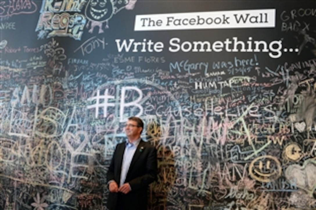 Defense Secretary Ash Carter stands in front of the Facebook wall during his visit to the company's headquarters in Menlo Park, Calif., April 23, 2015. Carter is on a two-day trip to Silicon Valley. Before visiting the company, Carter delivered a lecture at Stanford University, where he unveiled the Defense Department's new cyber strategy.