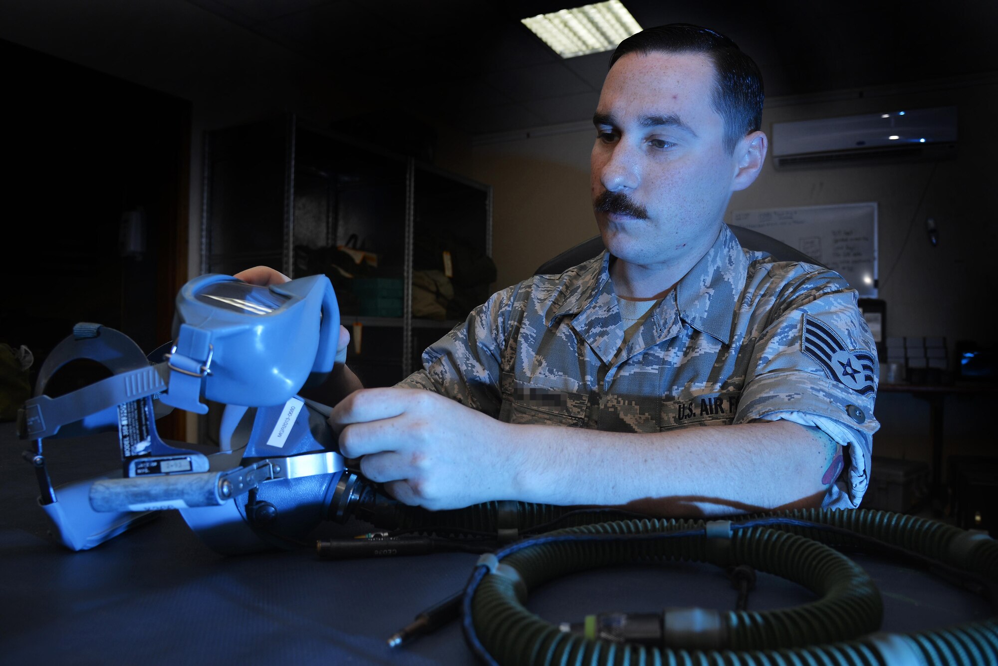 Staff Sgt. Scott performs an inspection of a quick-don mask at an undisclosed location in Southwest Asia April 15, 2015. The inspection ensured the mask was free of tears, holes, debris. Scott is an aircrew flight equipment technician assigned to the Expeditionary Operations Support Squadron. (U.S. Air Force photo/Tech. Sgt. Christopher Boitz)