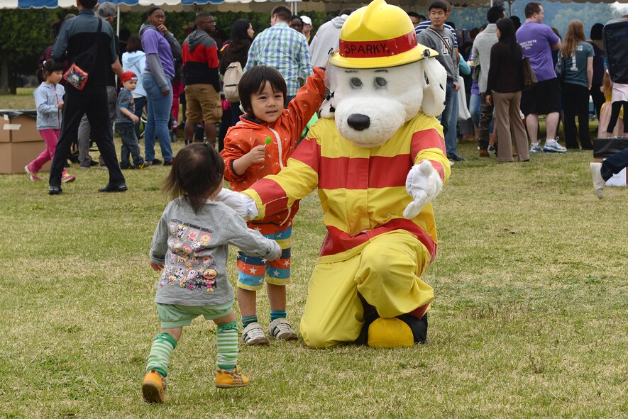 Children say hello to Sparky the Fire Dog April 19, 2015, at Yokota Air Base, Japan. Youth at Yokota were celebrated for the month of the military child at a Youth Festival. (U.S. Air Force photo by Senior Airman Desiree Economides/Released)