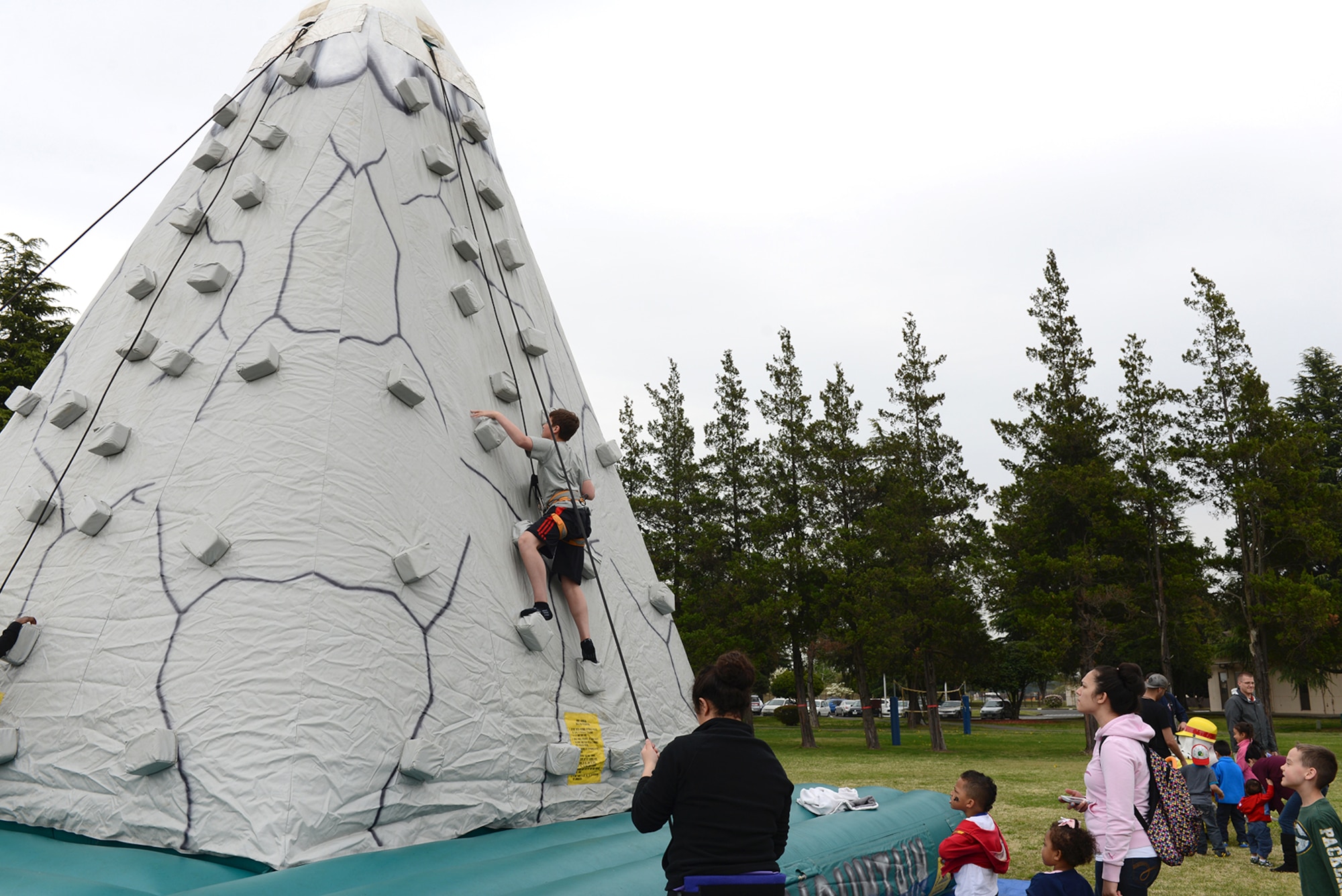 Children climb the rock wall and wait their turn during the Youth Festival April 19, 2015, at Yokota Air Base, Japan. Yokota hosted a festival for children to create, perform and compete for the month of the military child. (U.S. Air Force photo by Senior Airman Desiree Economides/Released)