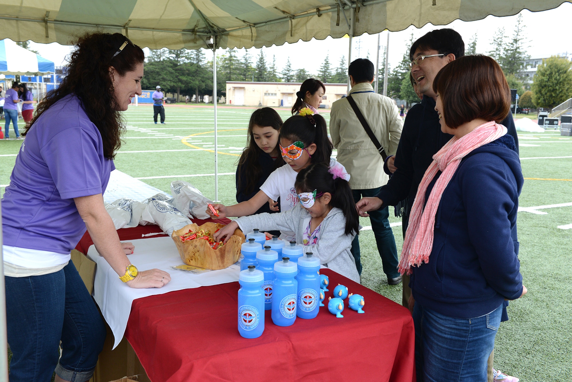 Children and their parents gather at an information booth during the Youth Festival April 19, 2015, at Yokota Air Base, Japan. Agencies and private organizations throughout Yokota supported the event for military children. (U.S. Air Force photo by Senior Airman Desiree Economides/Released)