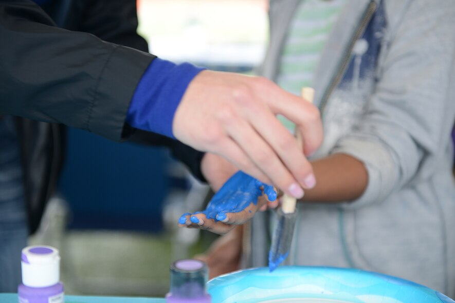 A child's hand is painted at a Family Advocacy booth at the Youth Festival April 19, 2015, at Yokota Air Base, Japan. Children and their parents left their handprints as a pledge of love. (U.S. Air Force photo by Senior Airman Desiree Economides/Released)