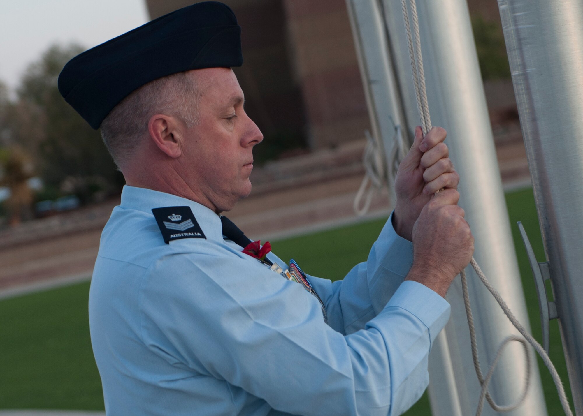 A member of the Royal Australian Air Force raises the Australian flag during the Anzac commemorative service April 25, 2015 at Holloman Air Force Base, N.M. Anzac, short for Australian and New Zealand Army Corps, originally meant someone who fought in the battle of Gallipoli, but later meant any Australian or New Zealander who fought in World War I. At dawn April 25 around the world, Australians gather to honor the more than 8,000 men lost in the battle of Gallipoli. Anzac Day is a day when Australians reflect on the many different meanings of war, and recognize the qualities of courage, mateship and sacrifice which were demonstrated at the Gallipoli landing. (U.S. Air Force photo by Airman 1st Class Emily A. Kenney/Released) 