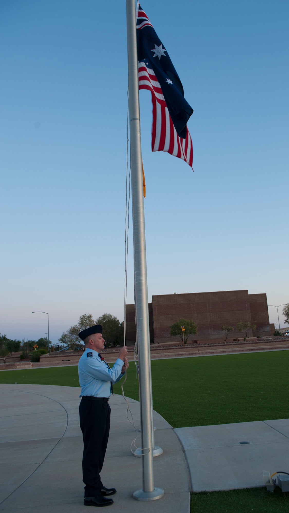 A member of the Royal Australian Air Force raises the Australian flag during the Anzac commemorative service April 25, 2015 at Holloman Air Force Base, N.M. Anzac, short for Australian and New Zealand Army Corps, originally meant someone who fought in the battle of Gallipoli, but later meant any Australian or New Zealander who fought in World War I. At dawn April 25 around the world, Australians gather to honor the more than 8,000 men lost in the battle of Gallipoli. Anzac Day is a day when Australians and New Zealanders reflect on the many different meanings of war, and recognize the qualities of courage, mateship and sacrifice which were demonstrated at the Gallipoli landing. (U.S. Air Force photo by Airman 1st Class Emily A. Kenney/Released) 
