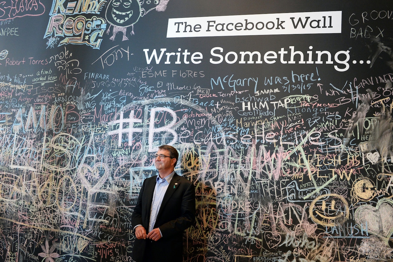 Defense Secretary Ash Carter stands in front of the Facebook wall during his visit to the company's headquarters in Menlo Park, Calif., April 23, 2015. Carter is on a two-day trip to Silicon Valley. Before visiting the company, Carter delivered a lecture at Stanford University, where he unveiled the Defense Department's new cyber strategy.  DoD photo by U.S. Army Sgt. 1st Class Clydell Kinchen 