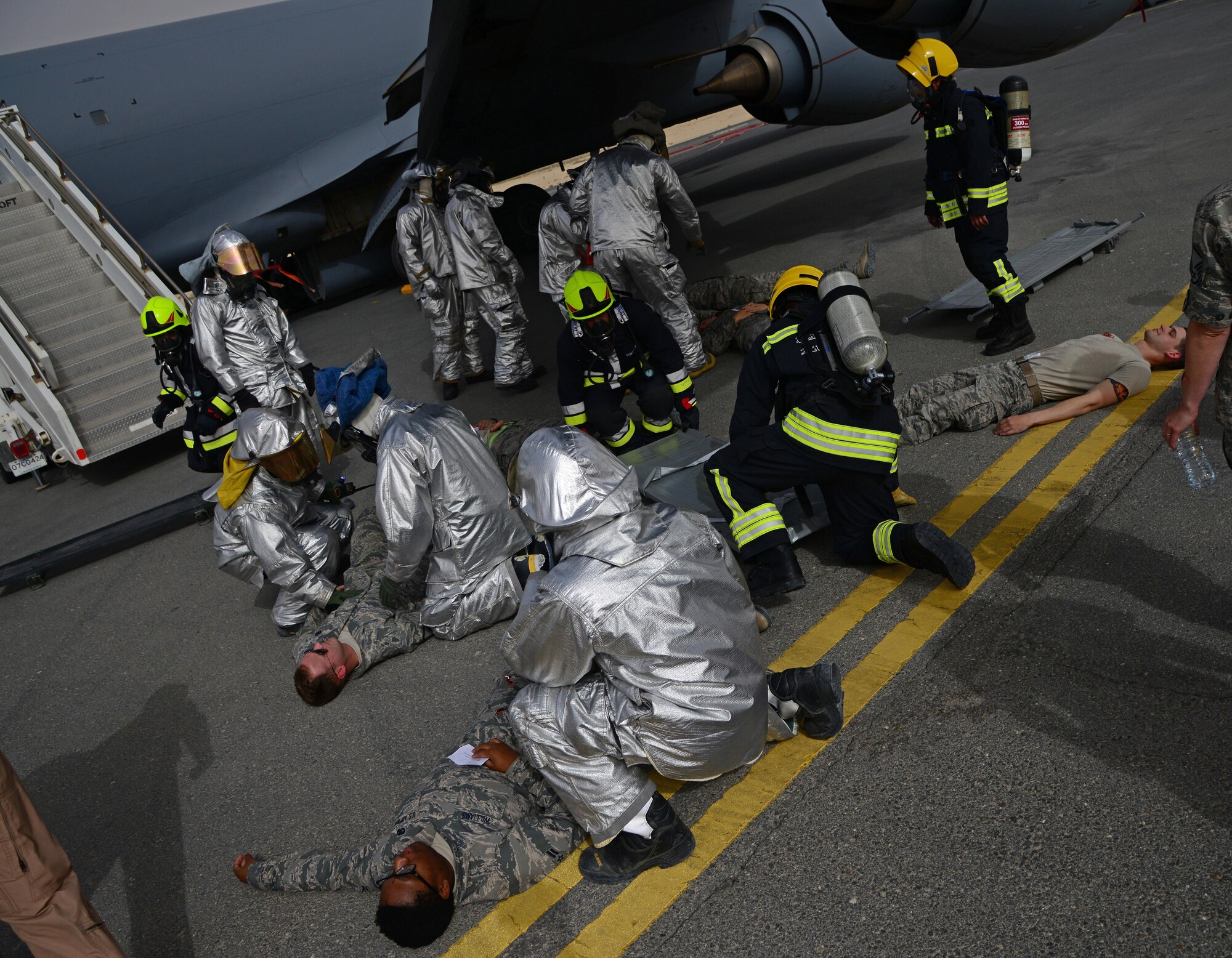 U.S. and Qatar Emiri Air Force firefighters tend to simulated victims of major aircraft accident on a KC-135 Stratotanker during a Major Accident Response Exercise, April 22, 2015, at Al Udeid Air Base, Qatar. The simulated patients were moved from the aircraft to a triage area where medical response teams categorize patients and transitioned them to higher levels of care. The MARE, which is a mission assurance exercise is required by all Department of Defense Bases on an annual cycle, ensures that personnel are properly trained and proficient at responding to incidents or threats in the event of a real world occurrence. (U.S. Air Force photo by Senior Airman Kia Atkins)