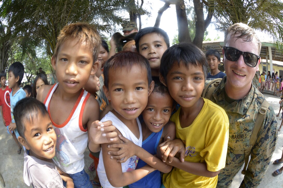 Philippine students from Santa Juliana Elementary School pose for a photo with a U.S. Marine during a community outreach event as part of Exercise Balikatan 2015 in Tarlac, Philippines, April 20. During the event, 25 Marines interacted with the students by reading books, playing games and sharing stories.