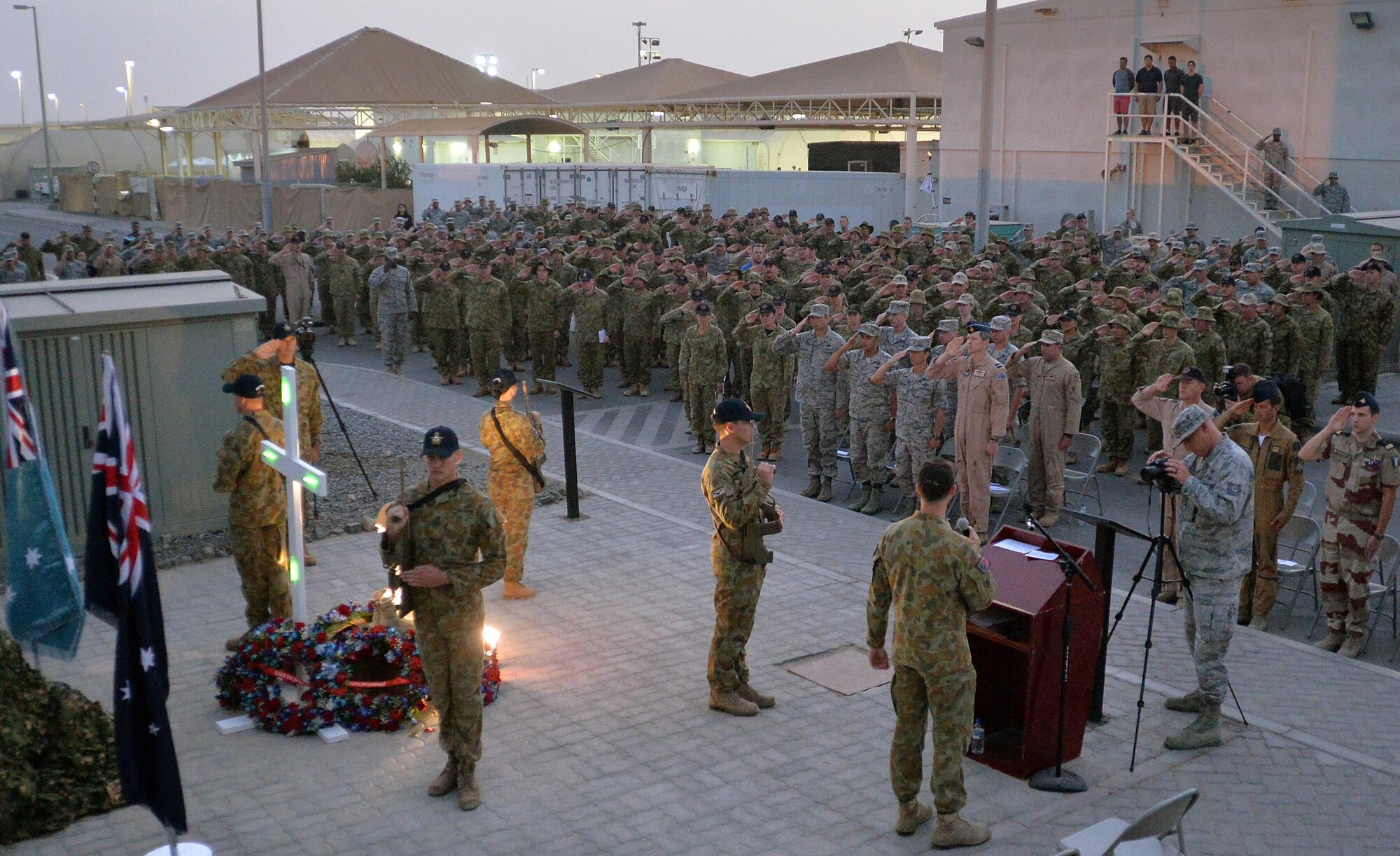Coalition forces render a salute during the Australian national anthem at an undisclosed location in Southwest Asia April 25, 2015. The ceremony recognized the sacrifices of those who served in the Australian and New Zealand armed forces over the last 100 hundred years. (U.S. Air Force photo/Tech. Sgt. Jeff Andrejcik) 