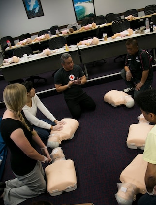 Students listen as Allen Balabis, regional director of emergency management, Marine Corps Installations Pacific, Marine Corps Base-Camp Butler, Japan, center, explains CPR during a class sponsored by the American Red Cross April 22 on Camp Foster, Okinawa. The class certified Marines and Master Labor Contractors in adult, child and infant CPR, use of an automated external defibrillator and basic first aid in the Education Center. CPR is a method used to maintain blood flow and brain function in an emergency situation such as a heart attack or drowning where the patient’s heart beat or breathing has stopped. 