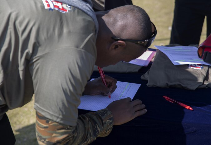 Lance Cpl. Kishun Parrott, a warehouseman with Combat Logistics Company 36, signs up for the Day of service event hosted by the Single Marine Program aboard Marine Corps Air Station Iwakuni, Japan, April 22, 2015. The Day of Service was an event made to show appreciation for the service members who have been volunteering with the SMP. They began the day picking up trash on and off base, afterwards they joined together at Penny Lake where SMP provided games, activities and refreshments for the volunteers.