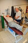 U.S. Navy Hospital Corpsman 1st. Class Mark Chase, who is assigned to the Kunar Provincial Reconstruction Team Field Surgical Team at Forward Operating Base Wright, prepares to take blood from U.S. Army Master Sgt. John Storey, noncommissioned officer in charge of operations for the 734th Iowa National Guard's Agribusiness Development Team. The blood was needed for immediate infusion into a seriously wounded Soldier, who needed whole blood of a particular type.