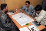 Lt. Col. Donald McCarty, left, deputy staff judge advocate for the 196th Maneuver Enhancement Brigade of the South Dakota Army National Guard listens as Rahim, center, a linguist for the 196th, explains a claim made by Naqeb, right, a local Afghan citizen. McCarty helps local Afghans file claims against the U.S. military when any incident, such as a car accident happens.