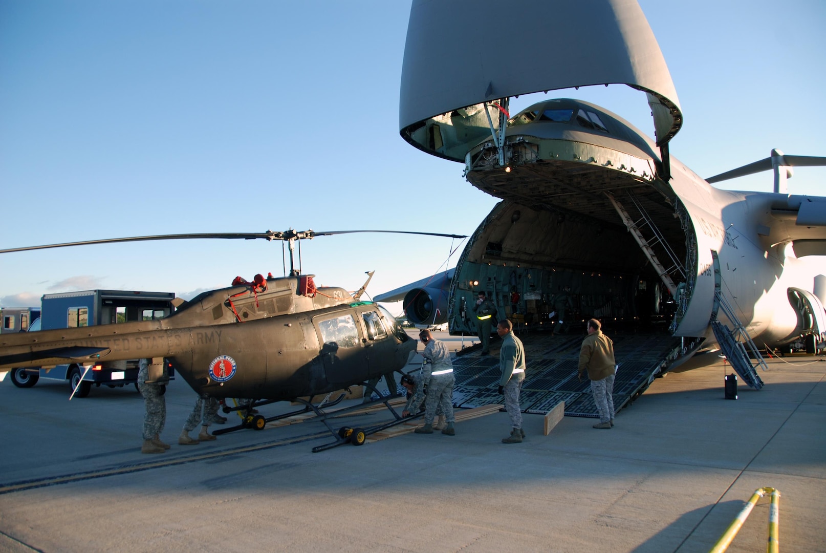 New York Army National Guard Soldiers with Detachment 1, Alpha Co, 1-224 Aviation Security and Support Battalion, unload an OH-58 Kiowa from a New York Air National Guard C-5 Galaxy at Air Force Base Ysterplaat Cape Town, South Africa Sept. 17, 2010. The team will participate in the African Aerospace Defence Exposition 2010.