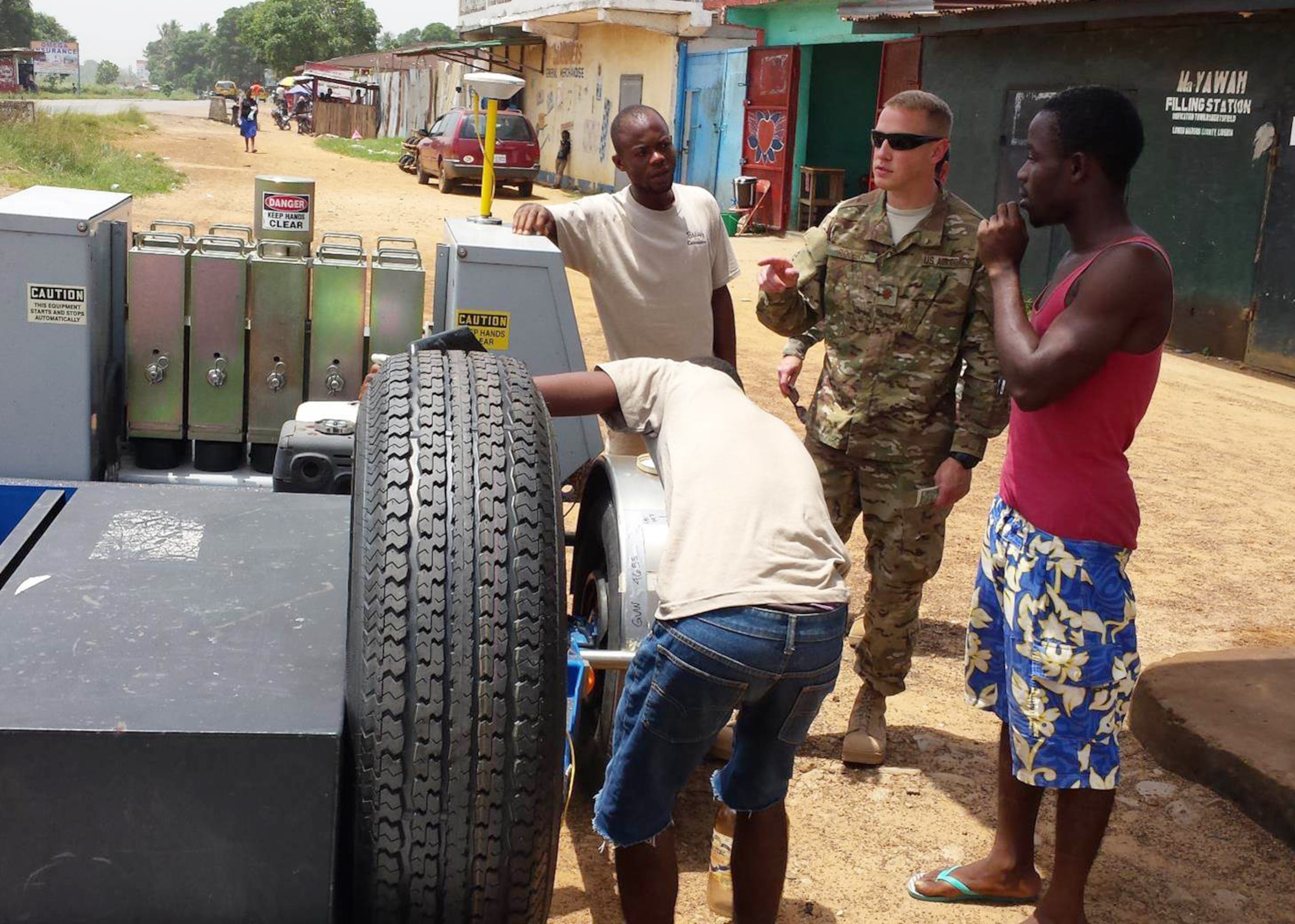 Maj. Robert C. Rogers, an Individual Mobilization Augmentee currently serving as the branch chief for the Air Force Civil Engineering Center’s Airfield Pavements Evaluation team, buys gasoline in glass jars from a local gas station in Liberia. (Courtesy photo/Master Sgt. James Dixon)