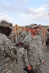 Army Brig. Gen. Lester Simpson, commander of the Texas Army National Guard's 176th Engineer Brigade, places a combat patch on the right sleeve of Army Capt. Thomas Loftis, commander of the brigade's Headquarters and Headquarters Company, at a ceremony on Forward Operating Base Sharana Sept. 11, 2010.