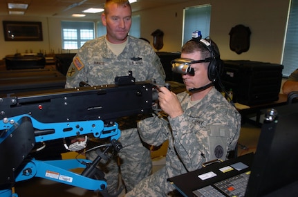 Staff Sgt. Anthony Burgess, center, a master gunner instructor with Charlie company, Warrior Training Center, Ft. Benning, Ga., instructs Sgt. Peter Hyland, the unit administrator for the New York National Guard's 1st Detachment, Headquarters and Headquarters Company, 27th Brigade Special Troops Battalion, on the new .50 caliber individual gunnery trainer at the 27th Brigade armory Sept. 15, 2010.