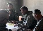 A Minnesota Guard member from Camp Mike Spann talks with local Afghans on election day in Afghanistan Sept. 18, 2010. The Minnesota Guard and the Croatian Operational Mentor and Liaison Team 47 performed vehicle and weapon systems inspections in preparation for a mission related to the elections.