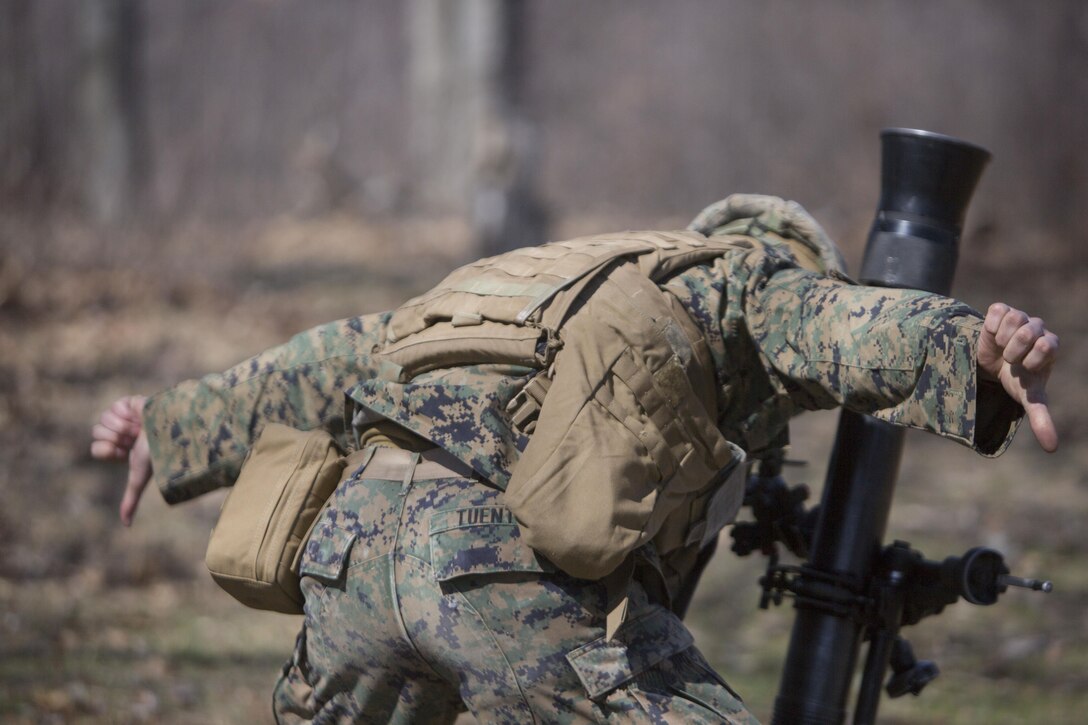 Cpl. Phillip M. Tuente, a mortarman with Weapons Company, 1st Battalion, 24th Marine Regiment, 4th Marine Division, Marine Forces Reserve, signals for a stake adjustment during Exercise Arctic Eagle at Camp Grayling, Mich., April 24, 2015. Mortarmen use stakes to help adjust the aim of the mortar before firing down range. (U.S. Marine Corps photo by Cpl. Ian Leones/Released)