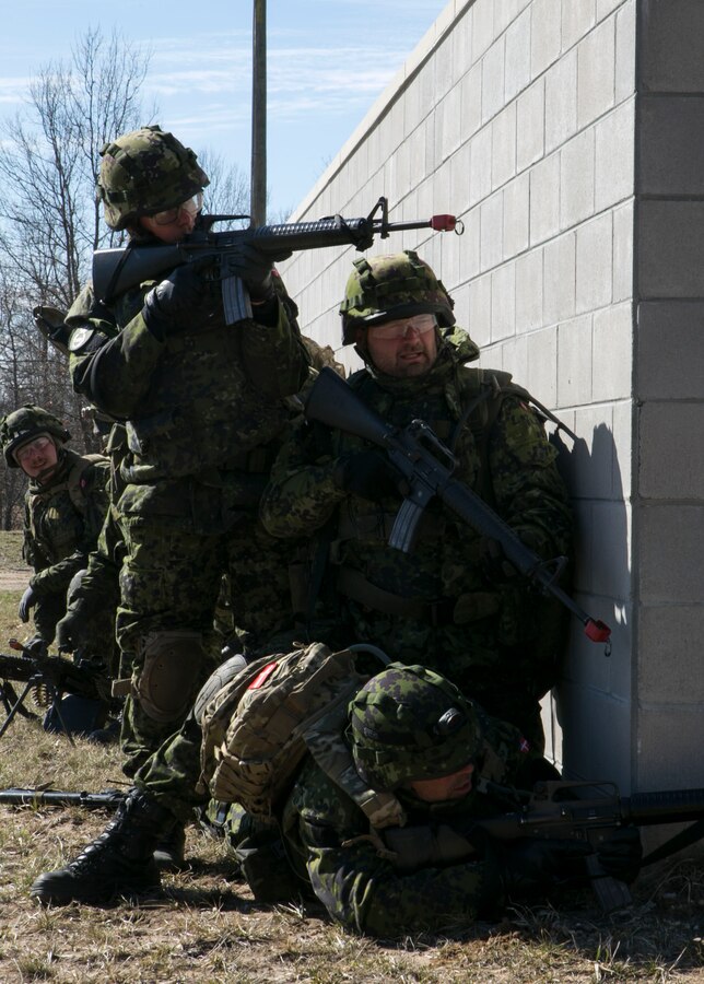 Soldiers with the Danish Home Guard prepare to advance on a position at Exercise Arctic Eagle at Camp Grayling, Mich., April 25, 2015. The soldiers joined Charlie Company, 1st Battalion, 24th Marine Regiment, 4th Marine Division, Marine Forces Reserve, in a simulation to retake a city from enemy insurgents at Camp Grayling's Combined Armed Collective Training Facility. (U.S. Marine Corps photo by Cpl. Ian Leones/Released)