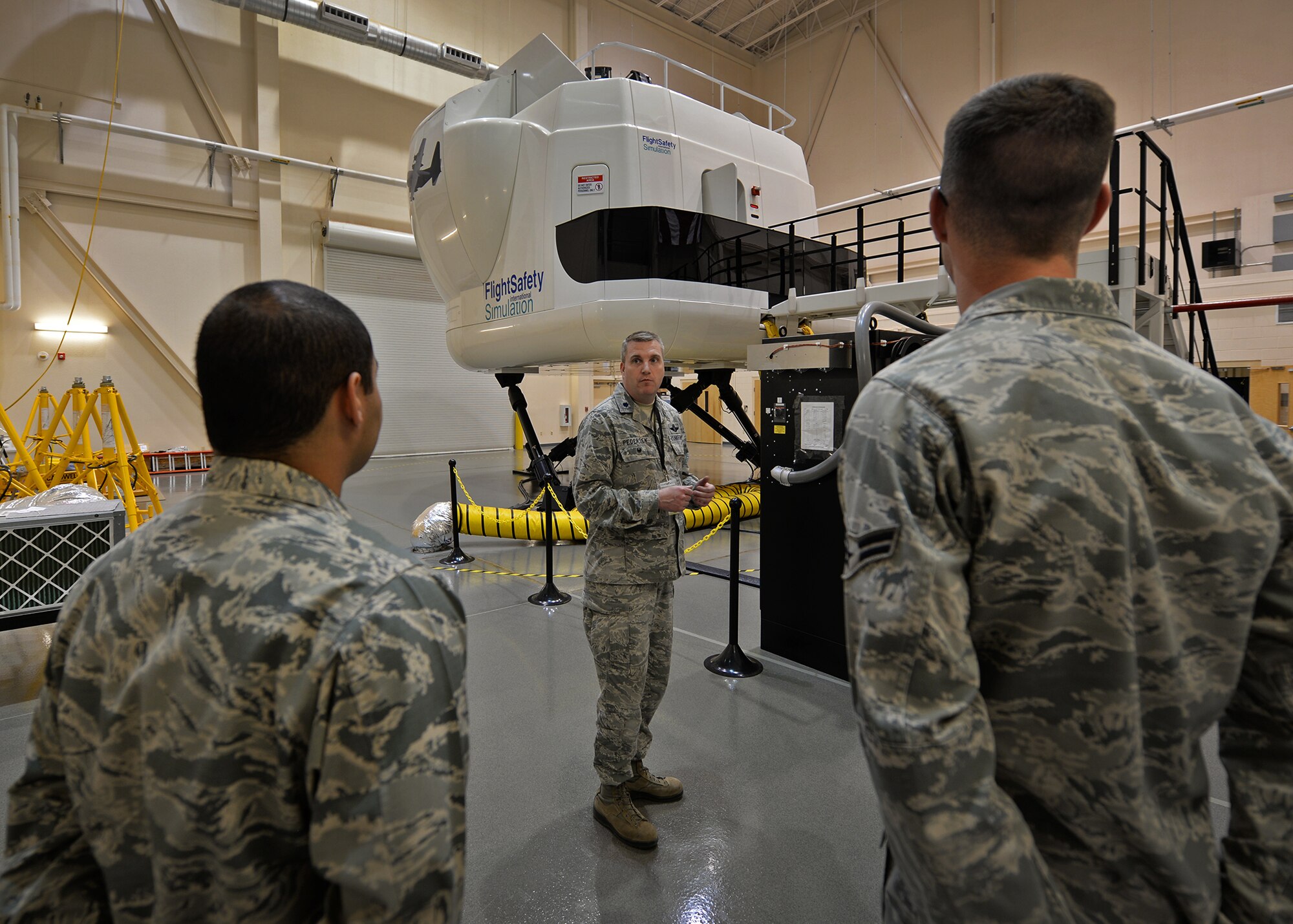 U.S. Air Force Lt. Col. Ken Pedersen, 27th Special Operations Wing Inspector General, explains the capabilities of the flight simulators to 27th Special Operations Wing Staff Agency Air Commandos April 21, 2015 at Cannon Air Force Base, N.M. Members of the 27th SOWSA had the opportunity to get in the cockpit of the simulator and were given the chance to follow a flight plan. (U.S. Air Force photo/Airman 1st Class Chip Slack)