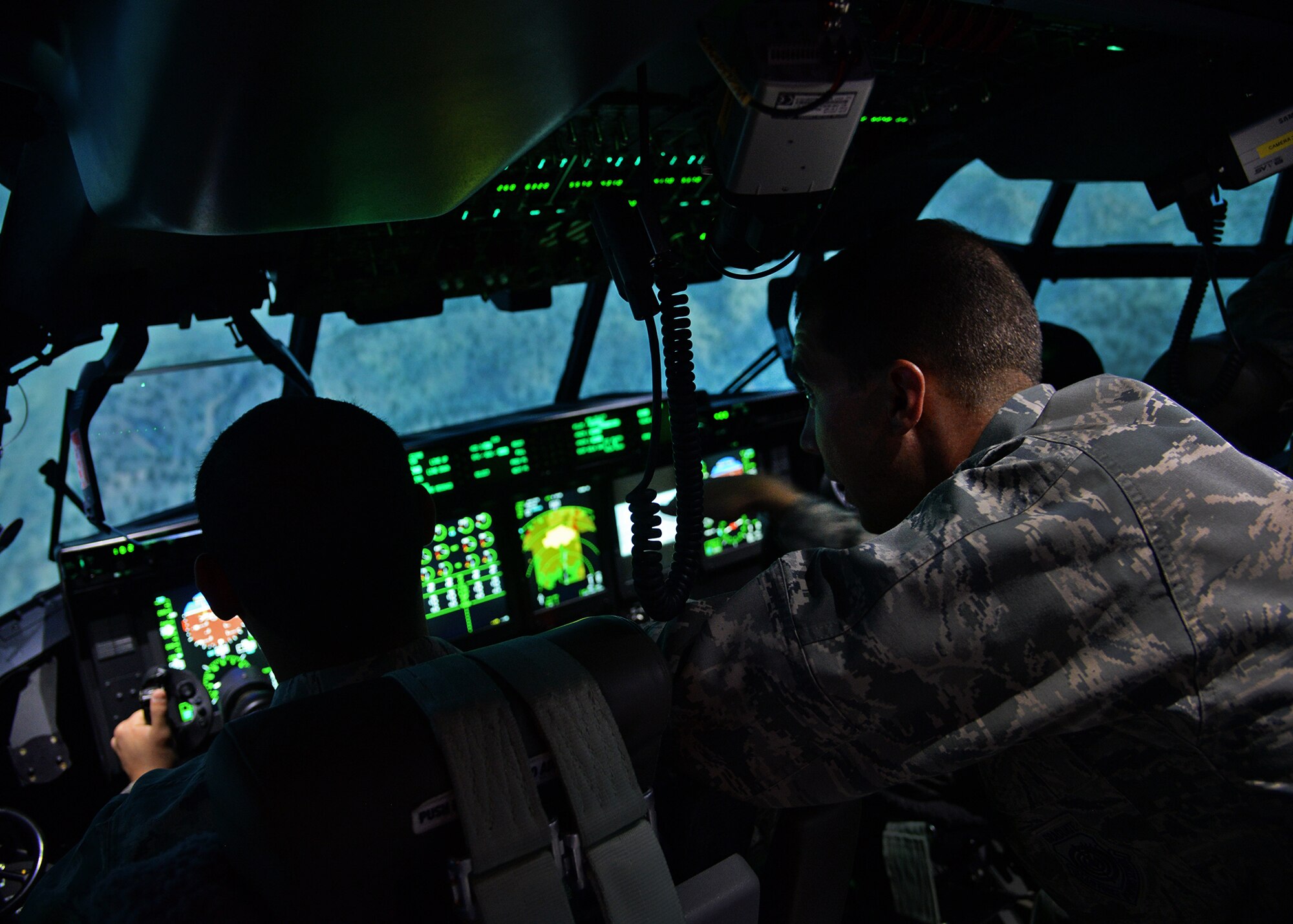 U.S. Air Force Maj. Kevin Bishop, 27th Special Operations Wing Inspector General deputy, explains the fundamentals of operating the MC-130 J Commando II flight simulator to 1st Lt. Melvin White, 27th SOW Director of Staff assistant, April 21, 2015 at Cannon Air Force Base, N.M. 27th Special Operations Wing Staff Agency Airmen had the opportunity to get an inside look at an essential part of the Cannon mission. (U.S. Air Force photo/Airman 1st Class Chip Slack)